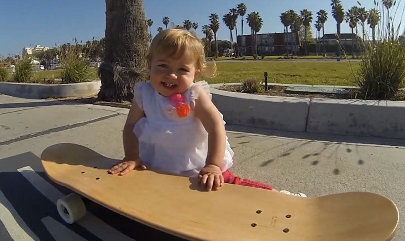 Un bébé sur un skateboard qui utilise une caméra GoPro